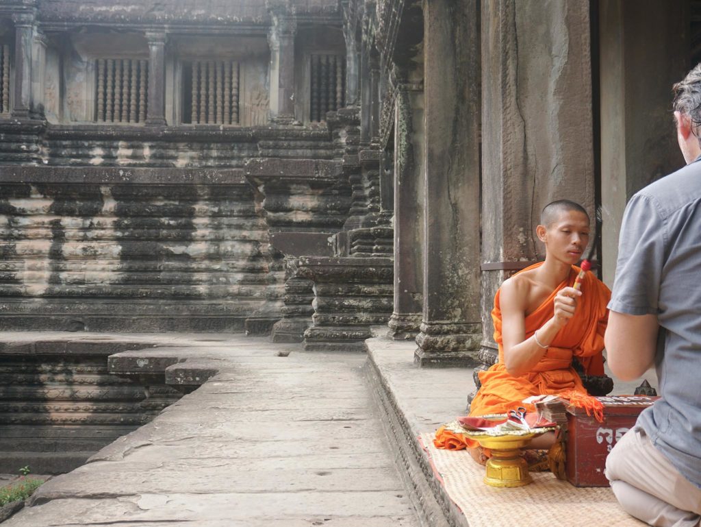 a-monk-doing-ritual-at-angkor